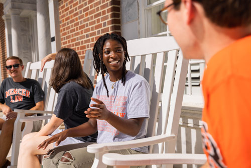 Casually dressed students chatting on a porch